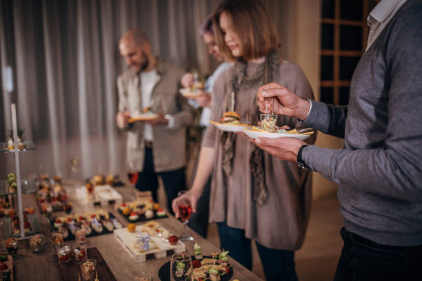 istock Business colleagues sampling savory dishes at corporate office party 1250598673