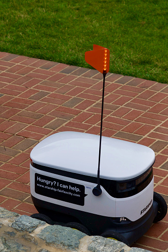 Fairfax, Virginia / USA - June 17, 2020: An autonomous delivery robot made by Starship Technologies awaits orders to pick up and deliver food to their next destination in Old Towne Square in the historic City of Fairfax.