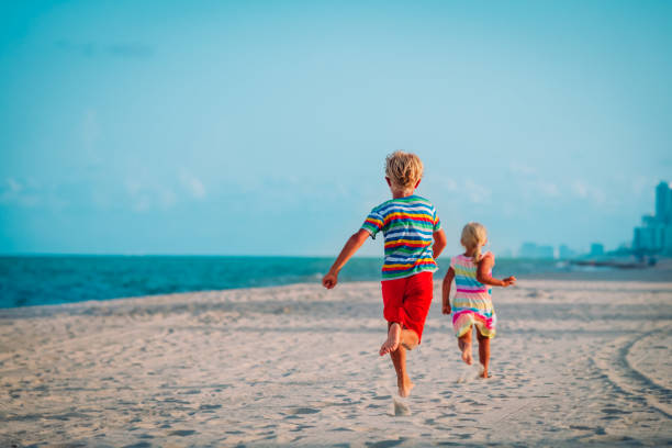istock boy and girl running on beach vacation 1250600998