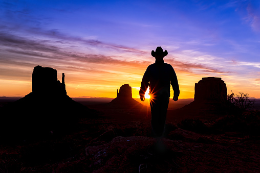 Cowboy Rancher in Monument Valley Arizona - Scenic Mittens buttes with rancher at sunsrise in Monument Valley, Arizona USA.