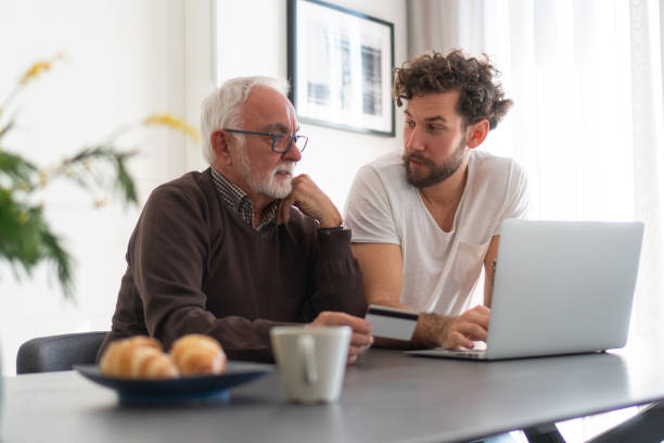 istock Grown son and senior dad using laptop 1250605165