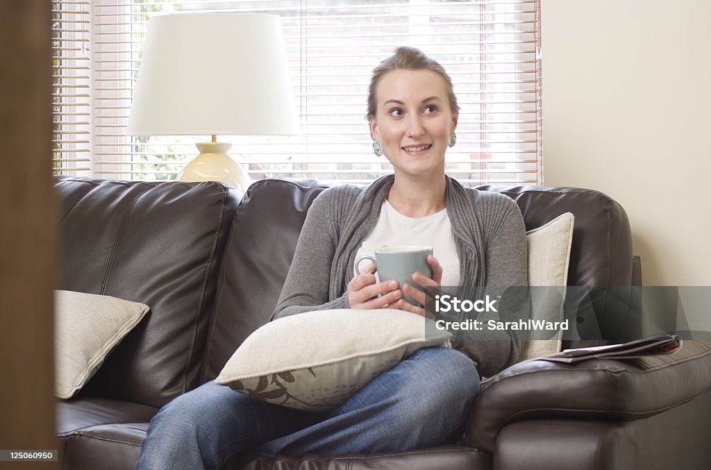 Donna giovane attraente rilassante a casa - Foto stock royalty-free di Abbigliamento casual