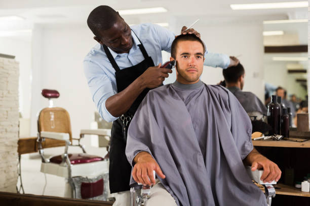 istock Man getting haircutting by African barber 1250611828