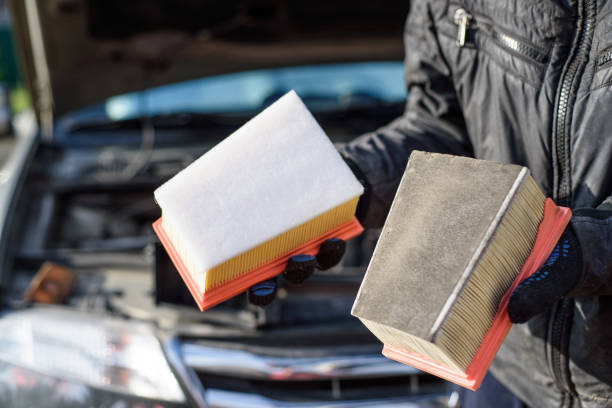 man replaces a dirty air filter for a new one in a car. car service - air filter car motor vehicle engine imagens e fotografias de stock