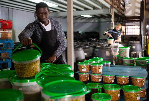 istock Man arranging plastic buckets with pickled olives 1250613240