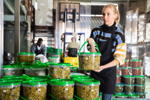 istock Girl arranging plastic buckets with pickled olives 1250613243