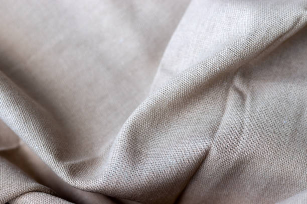 istock Natural beige linen fabric texture. Rough crumpled burlap background. Selective focus. Closeup view 1250613253