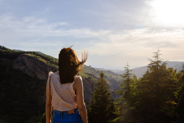 istock Nice woman looking at a mountain sunset while on vacation far from the city. Selective focus. 1250617223