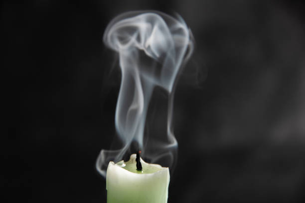 extinct light green candle with spectacular abstract smoke on a black background, close-up, abstraction.
