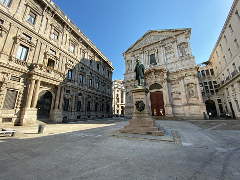 Milan, Italy - June 19, 2020: street view of Piazza San Fedele, with the monument dedicated to Alessandro Manzoni, in Milan during COVID-19 pendemic.