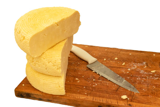 istock Sliced cheese on a wooden board with a knife isolated on white background 1250619649
