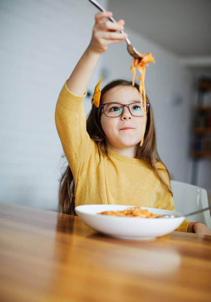 fille d’enfant fille heureuse pâtes de spaghetti mangeant l’enfance de repas de nourriture - child eating pasta spaghetti photos et images de collection