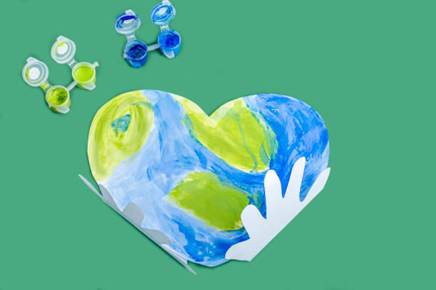 istock The Concept of DIY and children creativity. Step by step instruction: make applique from paper. Step 3 glued paper children palms to the Planet earth in the form of a heart. World Earth Day 1250620857