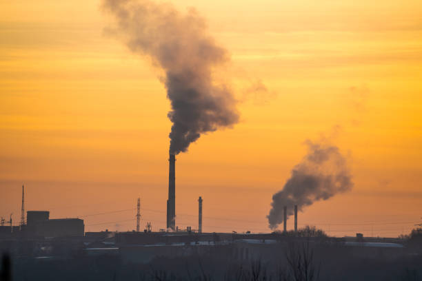 istock factory with pipes and smoke at sunset dawn. 1250620997