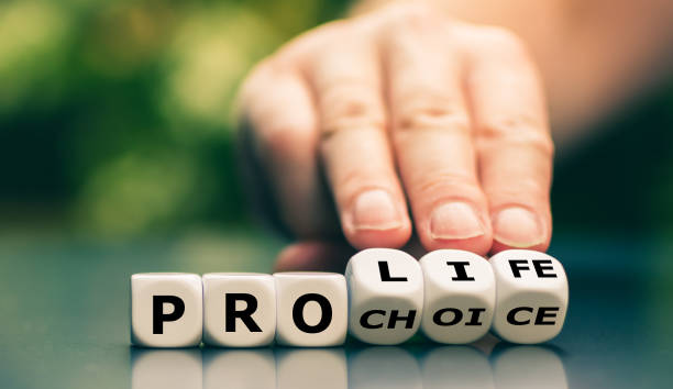 Hand turns dice and changes the expression "pro choice" to "pro life". stock photo