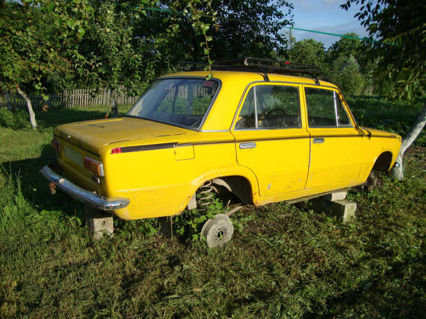 istock Yellow faulty retro car without wheels on grass 1250622724