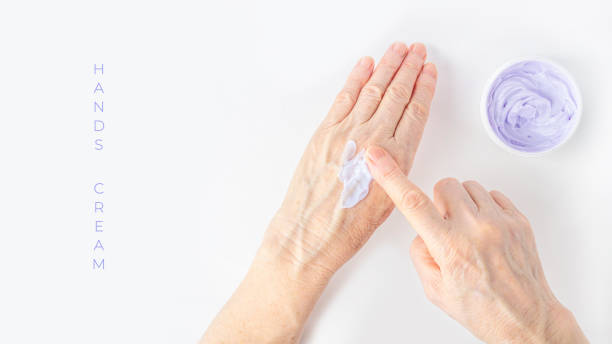 Elderly woman creaming her hands close up. Cosmetic moisturizing care for old skin. Anti-aging hand care and treatment. Ointment for the treatment of joints for the elderly. Elderly woman creaming her hands close up. Cosmetic moisturizing care for old skin. Anti-aging hand care and treatment. Ointment for the treatment of joints for the elderly. Copy space for text creaming stock pictures, royalty-free photos & images