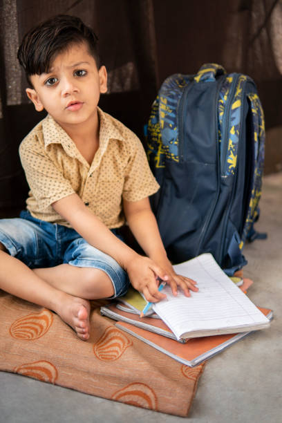 маленький мальчик студент учиться дома. - reading and writing little boys reading asian ethnicity стоковые фото и изображения