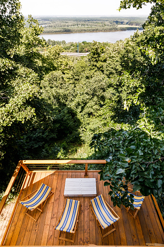 High angle view of balcony with deck chairs and table among greenery.