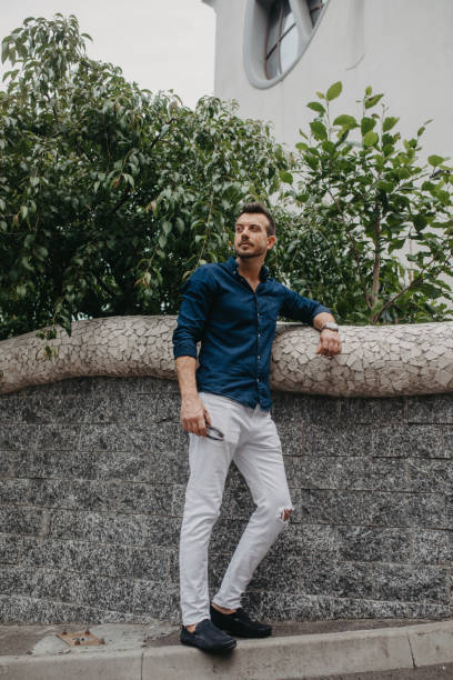 istock Young man stands with sunglasses near wall at street. 1250633607