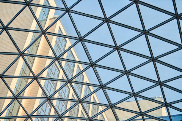 Transparent ceiling in business center. Glass triangle windows. Mesh structure architecture. Abstract geometric pattern of framed glass