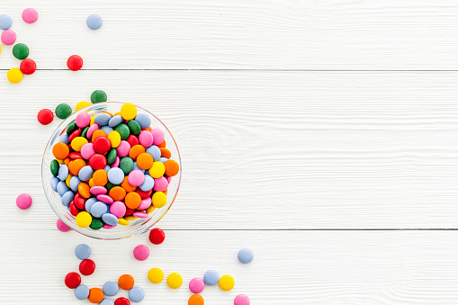 Colorful sweets on yellow desk from above.