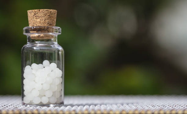 istock Homeopathy, globules in a glass bottle, nature background 1250638769