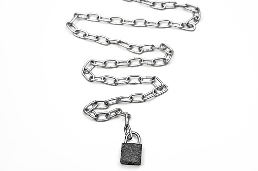 Padlock and metal chain on white background. The scene is situated in controlled studio environment in front of white background. Photo is taken with SONY AIII camera