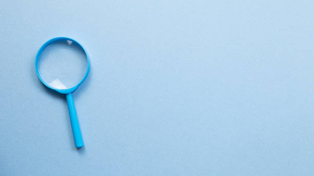 istock Blue magnifying glass on blue background. top view, copy space 1250647263