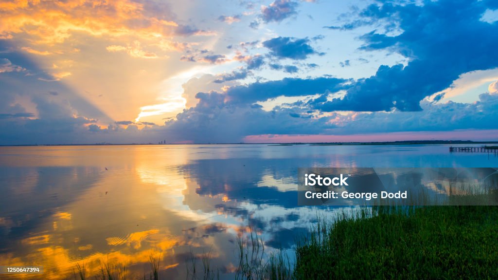 Vibrant sunset at Mobile Bay, Alabama Beautiful sunset on Mobile Bay from Daphne, Alabama Bayfront Park Beach Stock Photo