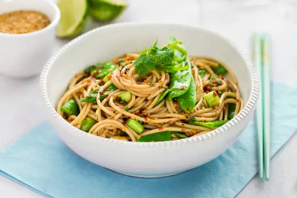 Sesame spaghetti with edamame beans and spring onions, chilli flakes