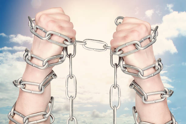 istock Two hands shackled a metal chain on blue sky background. Freedom concept 1250652049