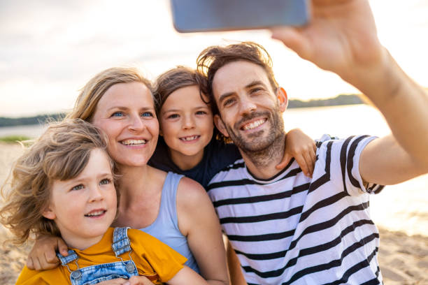 istock Family taking self portrait on beach 1250653424