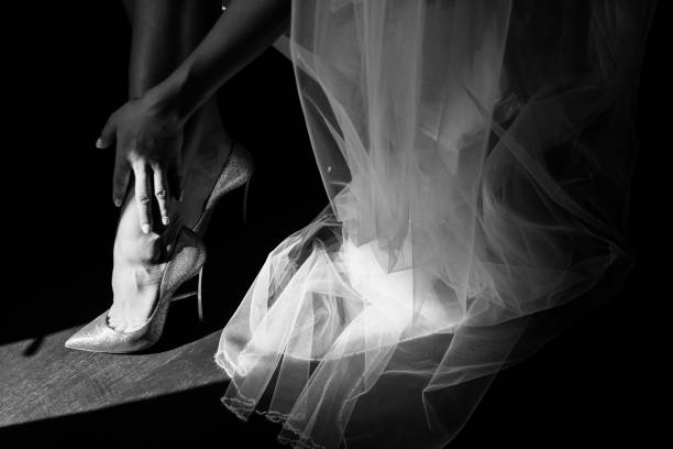 istock White wedding shoes on the bride's foot. Light and shadow. 1250654492