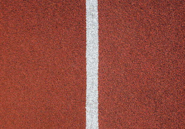 istock Red rubber running track texture close up. White divider line in the center. 1250658488