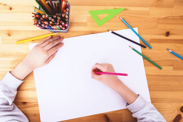 istock Schoolboy writting on white background. Top view. 1250661551