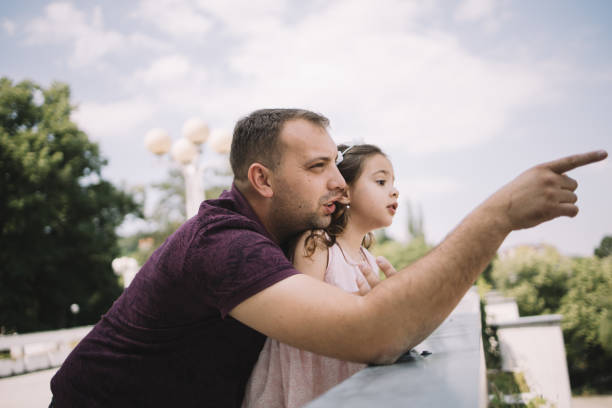 istock Close-up view of man pointing while hugging his daughter 1250665425