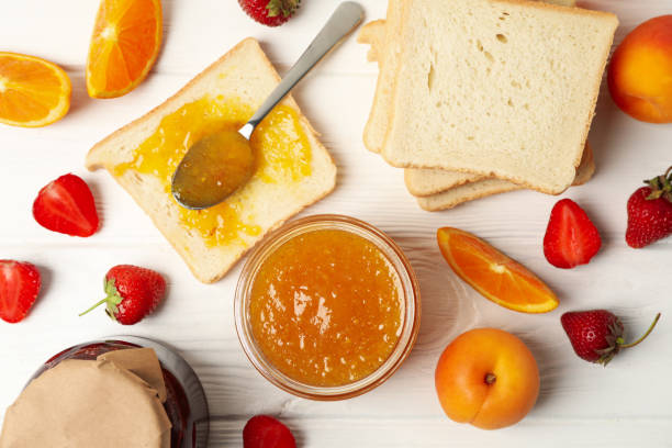 istock Composition with apricot jam on white wooden background. Sweet breakfast 1250674530