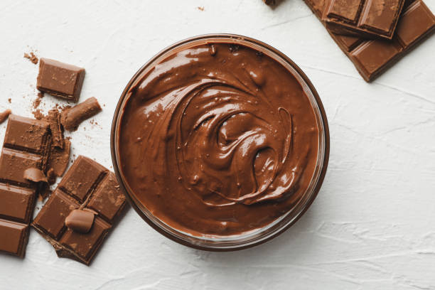 istock Bowl with chocolate and chocolate pieces on white background 1250675677