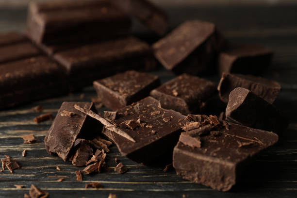 istock Chocolate pieces on wooden background, close up 1250675698