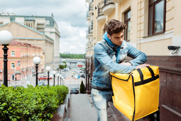 istock Courier holding thermo bag on urban street 1250675975