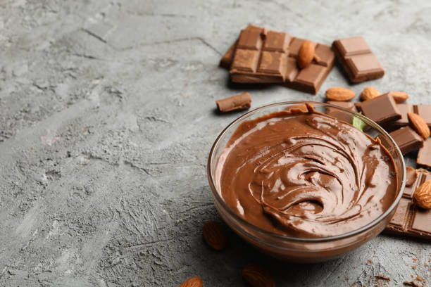 istock Bowl with chocolate and chocolate pieces on gray background 1250676868