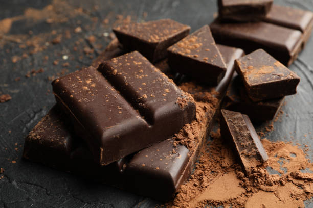istock Tasty chocolate and powder on black background 1250677022