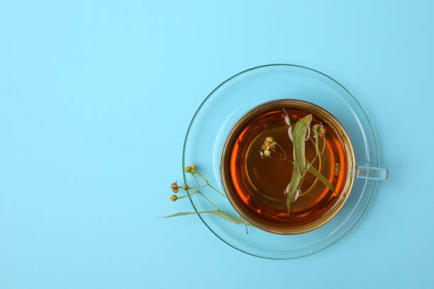 istock Cup of linden tea on blue background, top view 1250678252