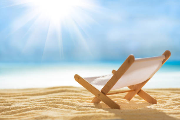 istock Deck chairs on sandy beach with blurry blue ocean and sky. Summer background. Soft focus 1250678305