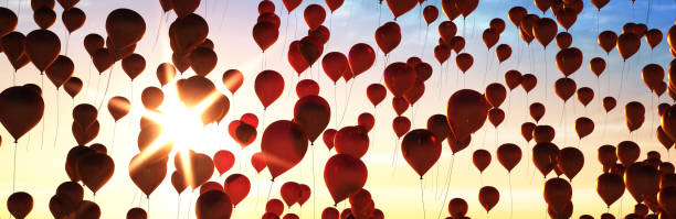istock Many Balloons Flying to the blue sky with sunlight 1250680700