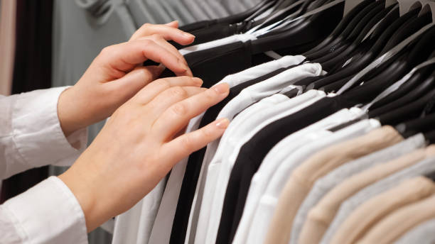 istock Female hands sorting cotton pullovers on a hanger in a clothing store 1250680709
