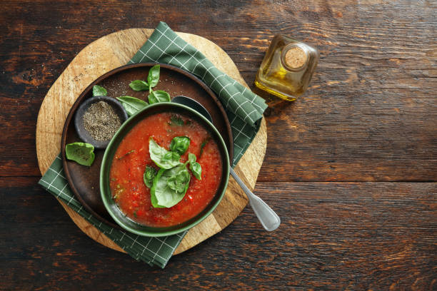 Homemade Vegan Creamy Roasted Tomato Basil Soup Homemade Vegan Creamy Roasted Tomato Basil Soup. Flat lay top-down composition on dark wooden background. Horizontal image with copy space. tomato soup stock pictures, royalty-free photos & images