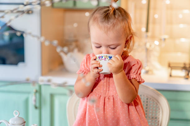 petite fille a fait la tasse de thé avec le gâteau dans kitchen.festive lunch.playing avec des enfants - tea party party tea little girls photos et images de collection