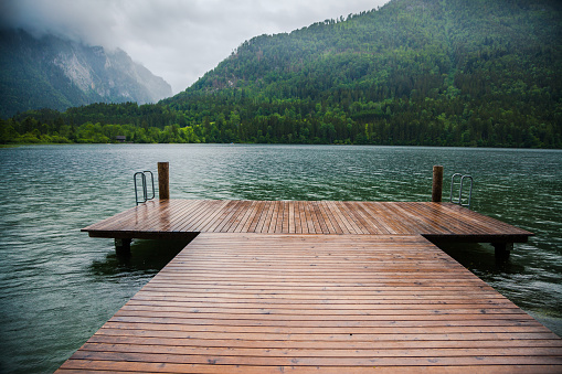 wet wooden jetty at a lake under the rain